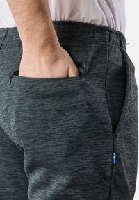 Black and gray marled athletic pants with a zipper pocket and small blue and yellow logo. Smooth texture with an elastic waistband.