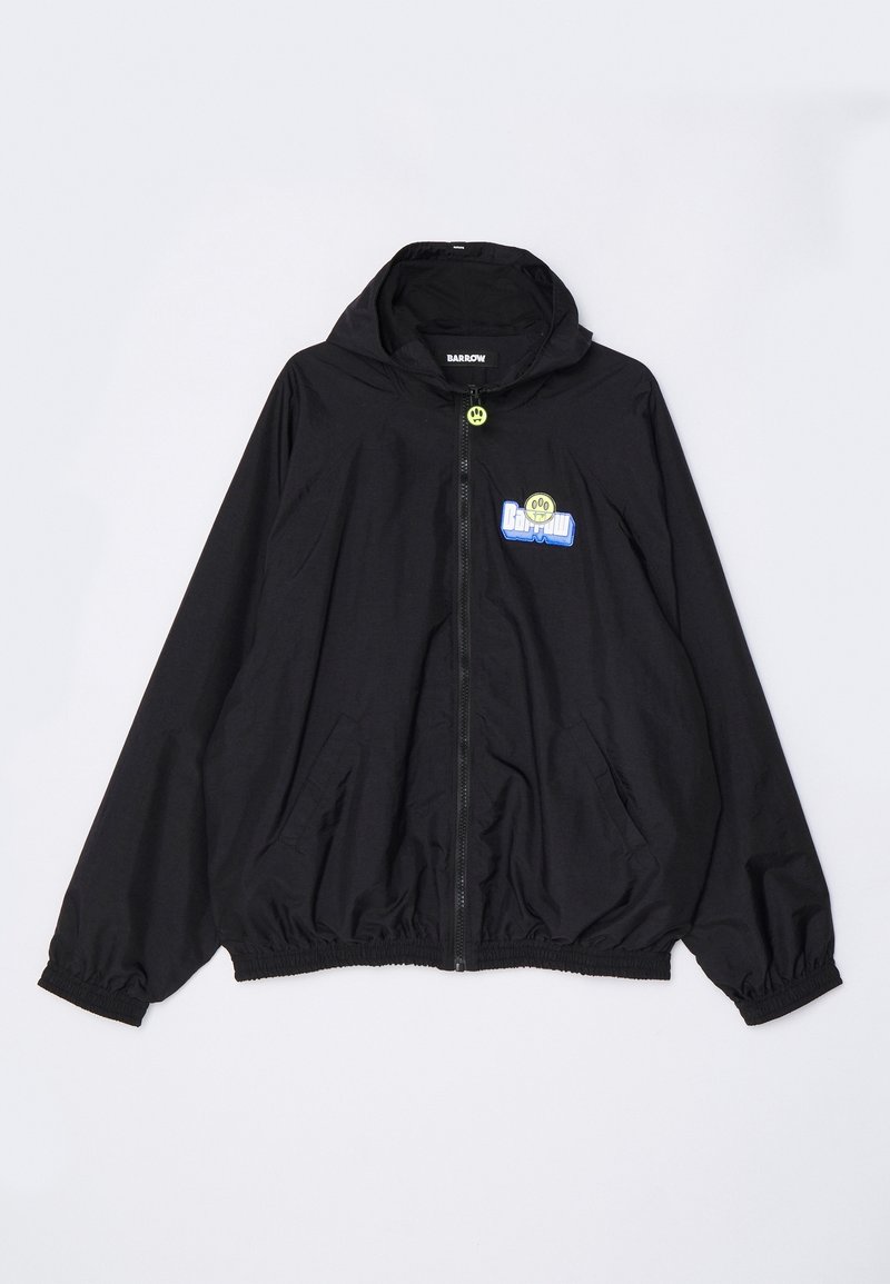 Svart lätt jacka med huva, framdragkedja, elastiska ärmslut och nederkant, med en flerfärgad logotyp på bröstet och fickor.