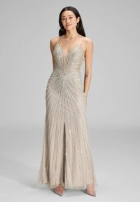 Beżowa suknia wieczorowa ozdobiona cekinami, z głębokim dekoltem, dopasowanym gorsetem i rozkloszowaną spódnicą z pionowymi paskami cekinów oraz rozcięciem z przodu.