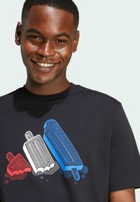 Camiseta de algodón negra con un gráfico de tres polos de hielo en rojo, blanco y azul, con patrones de puntos para textura y detalle.