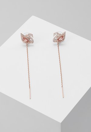 Rozen gouden oorbellen met druppelvorm, versierd met bloemenaccenten, ingelegd met heldere en roze edelstenen op een dunne ketting met rechte steunen.