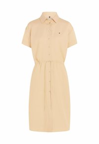 Abito camicia con bottoni in tessuto beige chiaro, dotato di colletto, maniche corte, vita cintrata e un piccolo logo sul petto.