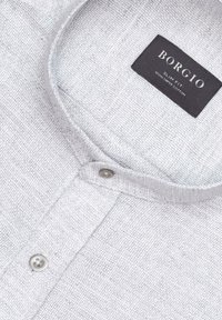 Jasnoszara koszula z kołnierzykiem o teksturowanej tkaninie, z zapięciem na guziki i czarną metką z napisem "BORGIO Slim Fit 100% Cotton".