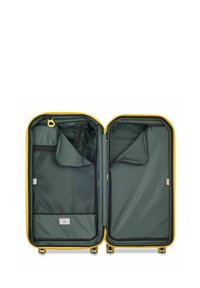 Valigia rigida gialla aperta, che presenta un interno verde scuro con tasche con zip e scomparti in rete per un'imballaggio organizzato.