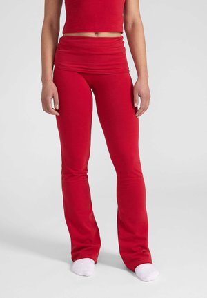Rode activewear outfit met een aansluitende crop top en flared leggings. Gemaakt van zachte stof, met een gladde textuur en een comfortabele tailleband.