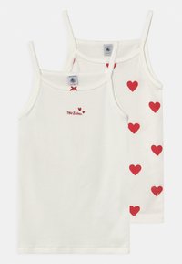 Due canottiere bianche in cotone con spalline sottili; una presenta un motivo a cuori rossi, mentre l'altra ha un piccolo logo rosso e un disegno a forma di cuore.