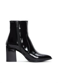 Bottines noires en cuir avec une finition brillante, à bout pointu et fermeture éclair sur le côté. Le talon épais offre une base solide. Texture lisse sur l'ensemble.