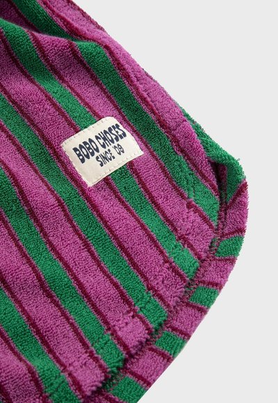 Tissu éponge rayé violet et vert avec une étiquette blanche cousue portant l'inscription "BOBO CHOSES DEPUIS 09".