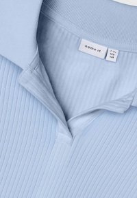 Hellblaues Polo-Shirt mit geripptem Muster, ausgestattet mit einem klassischen Kragen und einem Etikett mit der Aufschrift "name it", das die Größe 7-8 (122-128) angibt.