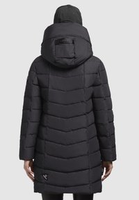 Doudoune noire avec un design matelassé en chevrons, dotée d'une capuche, d'un logo au dos et de manches longues. Convient pour les temps froids.