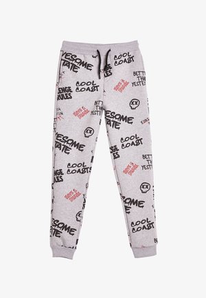 Pantalones de chándal grises con varios textos gráficos en negro y rojo y estampados de calaveras. Confeccionados en una tela suave, cuentan con cinturilla elástica y puños.