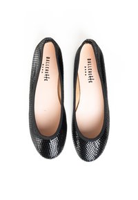 Bailarinas negras con un patrón reptiliano texturizado, punta redondeada y un suave forro interior. Los zapatos tienen un perfil flexible y delgado.