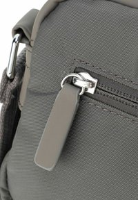 Borsa a spalla in tessuto grigio con superficie testurizzata. Caratterizzata da una zip metallica con un cordino grigio e un anello di attacco argentato.