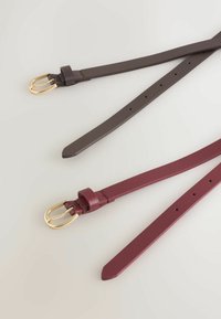Due cinture in pelle, una marrone scuro e una burgundy, entrambe con fibbie in metallo dorato. Ogni cintura presenta fori distribuiti uniformemente per la regolazione.