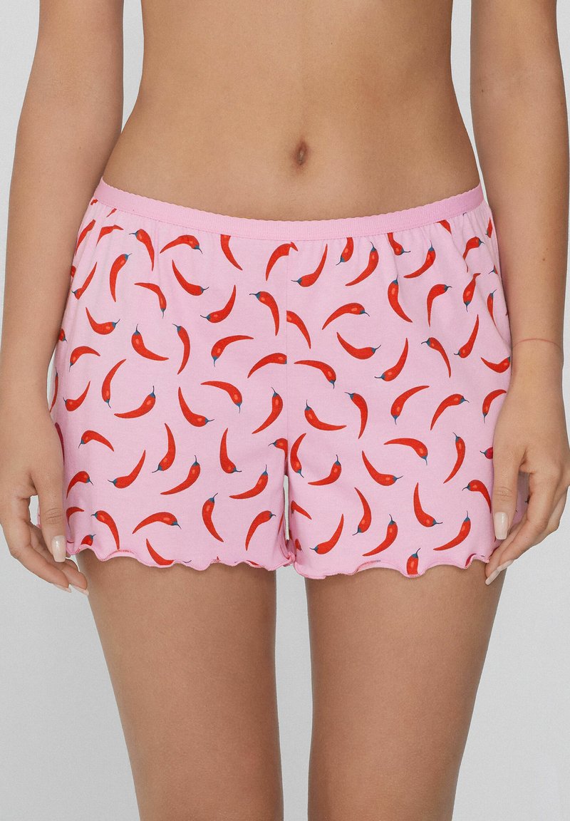 Roze katoen shorts met een speelse rode chilipoederpatroon, voorzien van een golvende zoom en een elastische tailleband.