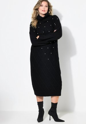 Schwarzes Rollkragen-Strickkleid mit gerippten Bündchen und Saum. Präsentiert ein Diamantmuster und perlartige Akzente zur Detailverfeinerung. Kombiniert mit schwarzen Absatzstiefeln.
