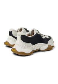 Schwarz-weiße Ledersneaker mit strukturierten Seitenpaneelen, Schnürverschluss und gepolsterter Sohle mit gelbem Vibram-Logo.