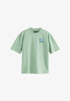 Fényzöld pamut póló rövid ujjakkal és kerek nyakkivágással. Bal melle tervezett grafikai nyomás található. Egyszerű design, sima textúra.