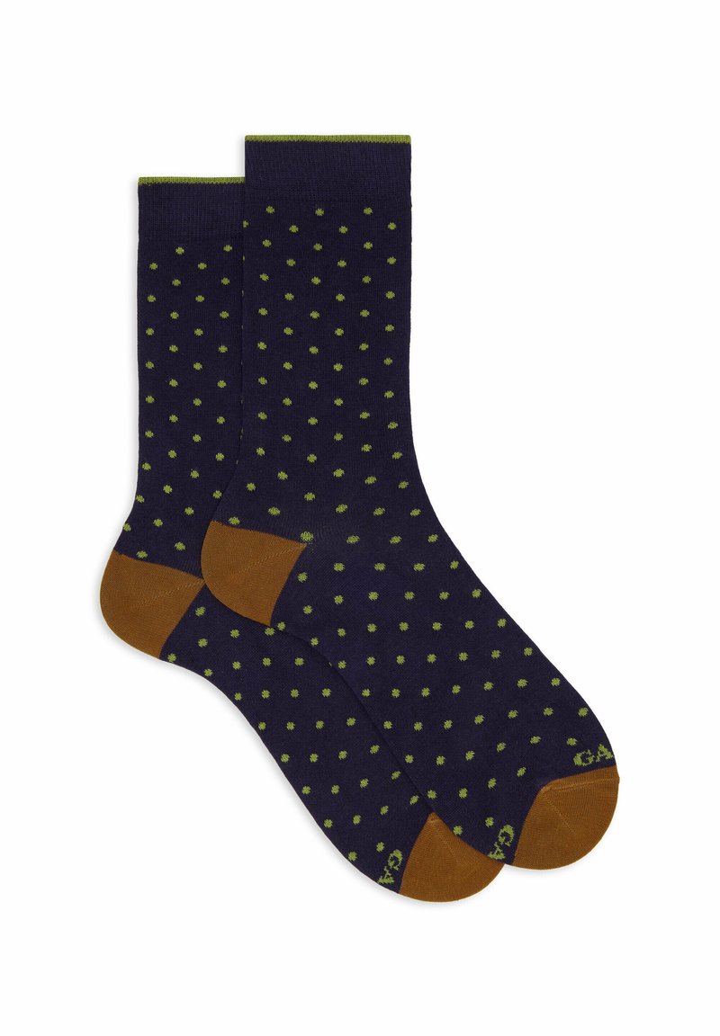 Marineblaue Socken mit kleinen grünen Punkten, braunen Fersen und Zehen sowie einem grünen Streifen an den oberen Kanten, flach ausgelegt.