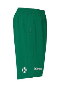 Green athletic shorts made of moisture-wicking fabric. Features an elastic waistband, side pockets, and white "Kempa" logo.