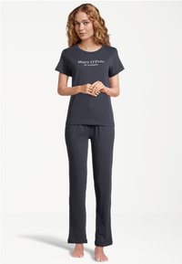 Mörkgrå matchande pyjamasset bestående av en kortärmad t-shirt med "Marc O'Polo"-logotyp och löst sittande, raka byxor. Slät textur.