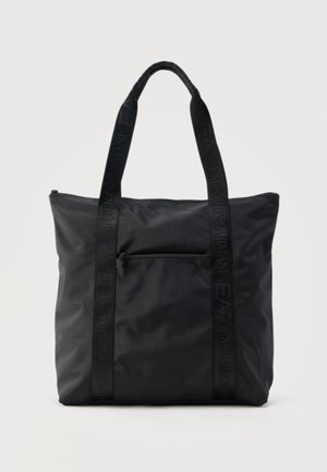 Borsa tote nera in nylon con due lunghe tracolle da spalla e una tasca frontale con cerniera, sfondo semplice.