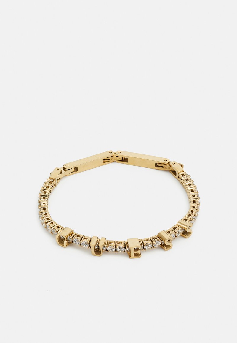 Bracelet en doré avec des segments alternés de maillons polis et de pierres scintillantes, fermé par un fermoir et des accents en lettres formant le mot "GUESS."