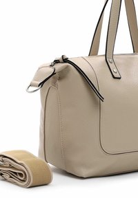 Beige Lederhandtasche mit schwarzen Akzenten und Reißverschluss, ausgestattet mit kurzen Griffen und einem großen Hauptfach. Inklusive gerolltem beigen Tragegurt.