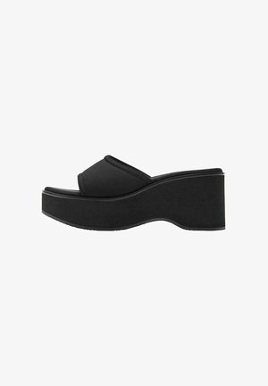 Sandalo platform nero con suola spessa e punta aperta, caratterizzato da una larga fascia che attraversa il piede e un leggero arco del tallone.