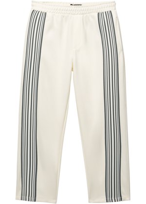 White athletic pants with gray vertical stripes along the sides. Features an elastic waistband and a smooth, textured fabric. Cropped length.