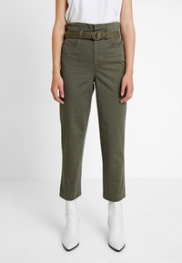 Olivově zelené bavlněné kalhoty s páskem a rovnými nohavicemi. Disponují dvěma předními kapsami a hladkou strukturou.