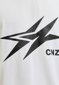 Valge T-särk, millel on suur must graafiline disain teravate nurkadega ja tekst "CNZ". Valmistatud pehmest kangast, millel on tekstureeritud pind.