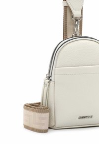 Bílá texturovaná kožená crossbody taška s dvojitým zipem, nastavitelný béžový popruh s geometrickým vzorem a detailem loga.