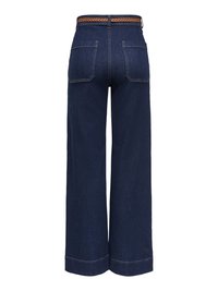 Jean en denim bleu foncé à jambes larges avec une ceinture tressée marron. Comprend deux poches arrière et des surpiqûres contrastantes le long des coutures.