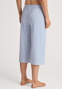 Light blue culotte pants with a white speckled pattern, featuring an elastic waistband and a relaxed fit, made from soft fabric.
