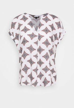 White short-sleeve blouse with V-neck and repeated intricate red and black geometric floral pattern.