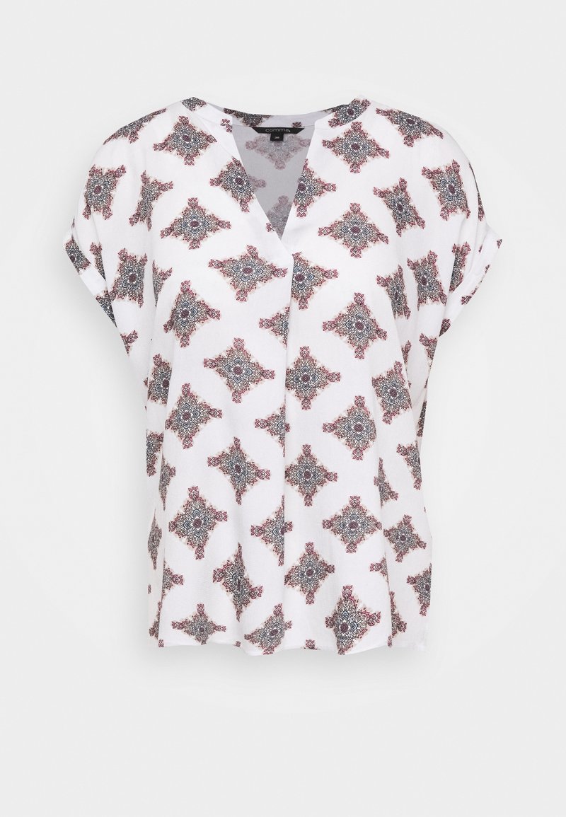 Blouse blanche à manches courtes avec col en V et motif floral géométrique rouge et noir complexe et répété.
