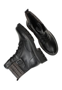 Bottines en cuir noir avec un revers en tissu à motifs, à lacets et fermeture éclair, semelles en caoutchouc épais et détail de boucle sur le côté.