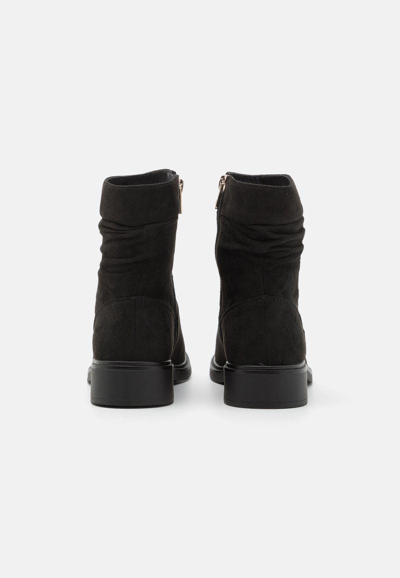 Schwarze Wildleder-Ankle Boots mit einer glatten Oberfläche, gerafftem Textur und einem niedrigen Blockabsatz. Mit einem seitlichen Reißverschluss zum Schließen.