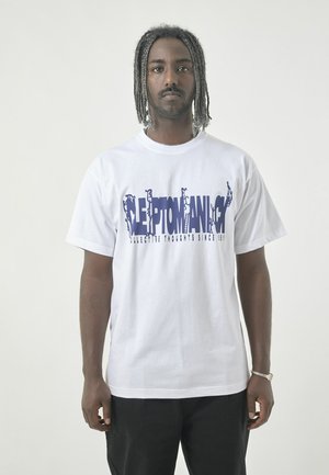 White cotton t-shirt featuring a blue graphic text "CLEPTOMANIC" with stylized figures. The shirt has short sleeves and a round neckline.