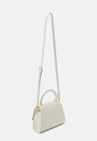 Sac à main en simili cuir blanc avec une anse supérieure et une bandoulière amovible. Présente des accessoires en or et une texture lisse, avec une forme rectangulaire.