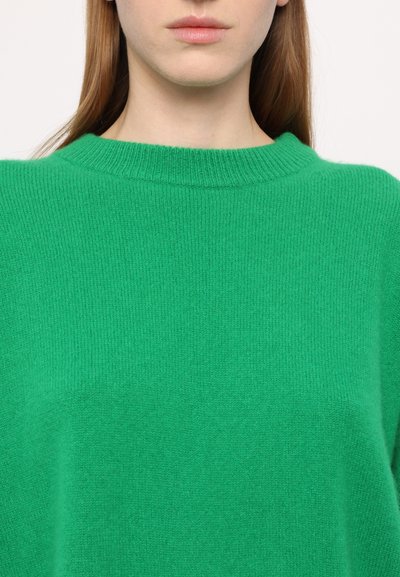 Green knitted sweater with a ribbed crew neckline and a soft, textured finish. The material appears lightweight and cozy.