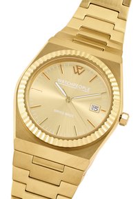 Reloj de tono dorado con un bisel texturizado, una esfera minimalista que presenta manecillas plateadas y un indicador de fecha. Fabricado en acero inoxidable.
