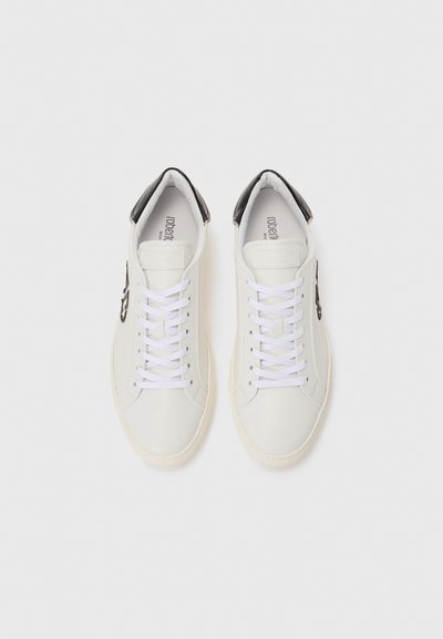 Pair of white low-top sneakers with black heel tabs and white laces, viewed from above on a plain white background.