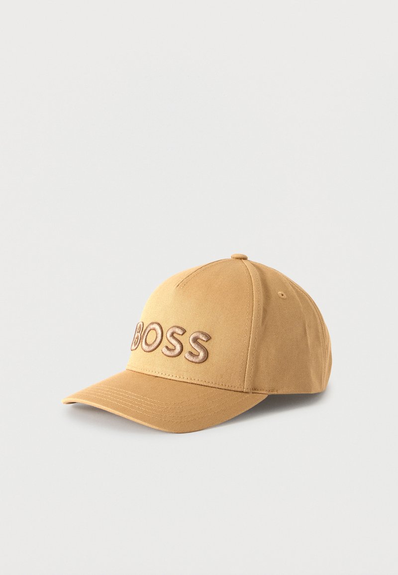 Casquette de baseball beige avec une visière incurvée et un texte brodé en relief « BOSS » à l'avant, présentée sur un fond clair uni.