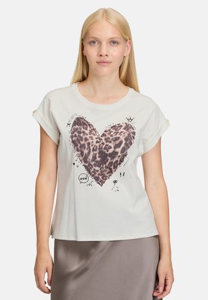 Hvid kortærmet t-shirt med et leopardprint hjerte design, accentueret af doodles og mønstre. Blødt stof, løs pasform.