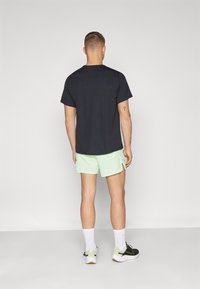 Nike Performance SECONDSUNRISE - Kurze Sporthose - vapor green/black