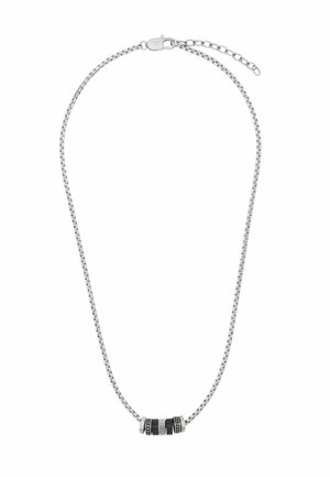 Srebrny naszyjnik z łańcuszkiem i małą cylindryczną zawieszką z czarnymi i srebrnymi rowkowanymi oraz nakropkowanymi segmentami.