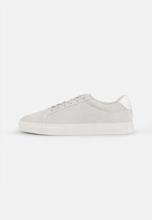 Világosszürke velúr sneakers, lekerekített orral, lapos fehér talppal és ezüst színű sarokdísszel. Fűzős kialakítás minimális varrási részletekkel.