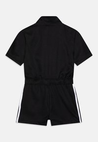 Black short-sleeve romper with collar, elastic waistband, and white side stripes on shorts, shown from the back on a plain background.